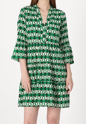 Grünes und cremefarbenes gemustertes Kleid mit geometrischem Design, das einen Kragen, drei Viertelärmel und einen geschichteten Rüschensaum hat.