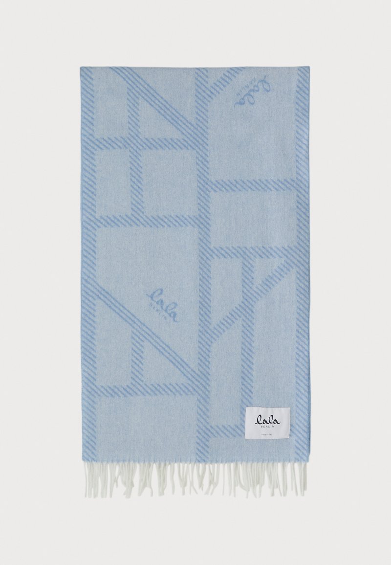 Coperte di colore azzurro chiaro con un motivo geometrico in linee blu scuro. Rifinita con frange bianche. Presenta una piccola etichetta del marchio in basso.