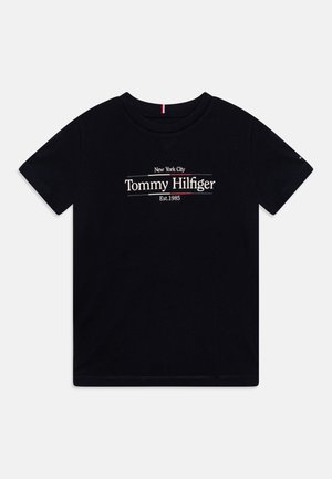 T-shirt noir à manches courtes avec l'inscription "New York City Tommy Hilfiger Est. 1985" imprimée en blanc et rouge sur la poitrine.
