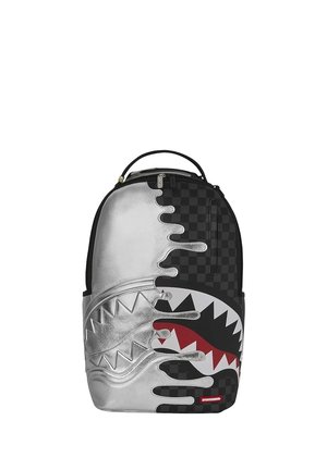 Mochila con patrones a cuadros mitad metálico plateado y mitad negro, con diseño estilizado de boca de tiburón en la parte frontal.