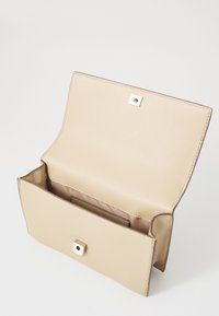 Beige läderclutch med en strukturerad yta, utrustad med ett guldmetallknäpp och en intern ficka. Öppen design för enkel åtkomst.