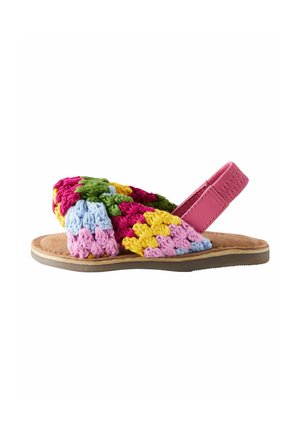 Flad sandal med en lyserød læderankelrem og farverige hæklede remme i grøn, gul, lyserød, lilla og blå på en beige sål.