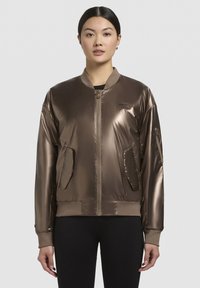 Bronzová bomber bunda s hladkým, lesklým povrchem, žebrovanými manžetami a spodním lemem, zapínáním na zip a bočními kapsami. Minimalistický design s logem.