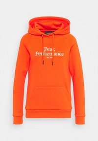 Sweat à capuche orange en tissu doux, avec une poche kangourou à l'avant, un cordon de serrage réglable, et un texte blanc indiquant "Peak Performance Est. 1986."