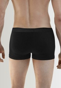 Czarne slipy wykonane z gładkiego materiału z elastycznym pasem z logo. Charakteryzują się dopasowanym krojem i minimalną ilością szwów dla większego komfortu.