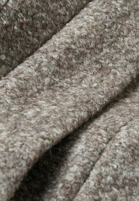 Tissu feutré dans des nuances de brun avec une texture mouchetée, présentant une surface douce et duveteuse ainsi que des plis superposés.