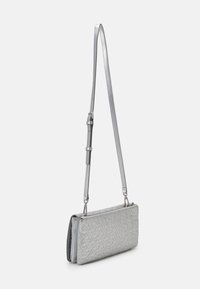 Borsa a tracolla argento con design del logo testurizzato, forma rettangolare slim, tracolla regolabile e chiusura con zip. Materiale liscio con finitura lucida.