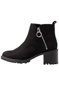 Stivaletti neri alla caviglia in suede con un pannello laterale testurizzato, dotati di una cerniera in argento e di un tacco in gomma spesso.