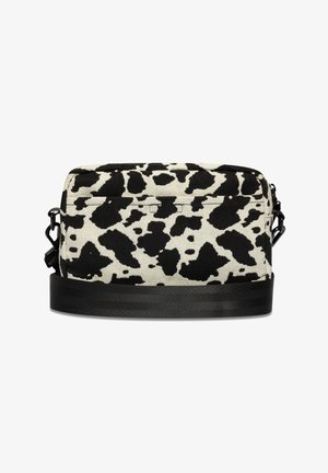 Sac à bandoulière en toile noir et blanc avec un motif imprimé vache, équipé d'une sangle noire et d'une fermeture éclair. Forme rectangulaire avec une surface texturée.