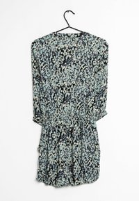 Blommönstrad klänning med långa ärmar, elastisk midja och svart bas. Färgerna inkluderar ljusblått, krämfärgat och mörka toner.