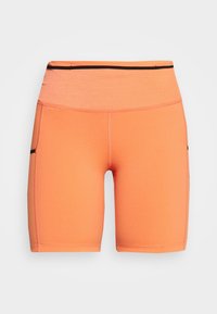 Pantalones cortos ajustados naranjas hechos de material elástico, con una cintura alta y bolsillos laterales negros para mayor funcionalidad.