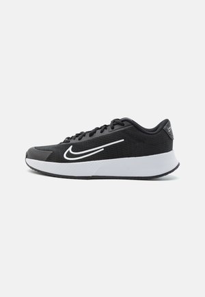 Baskets de sport noires avec une tige en maille, fermeture à lacets, logo Swoosh blanc et semelle intermédiaire blanche contrastante. Semelle en caoutchouc texturée pour une meilleure adhérence.