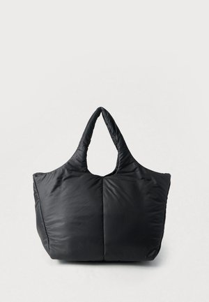 Grand sac fourre-tout noir matelassé avec des doubles poignées, une texture douce matelassée et une large base rectangulaire, debout sur un fond blanc.