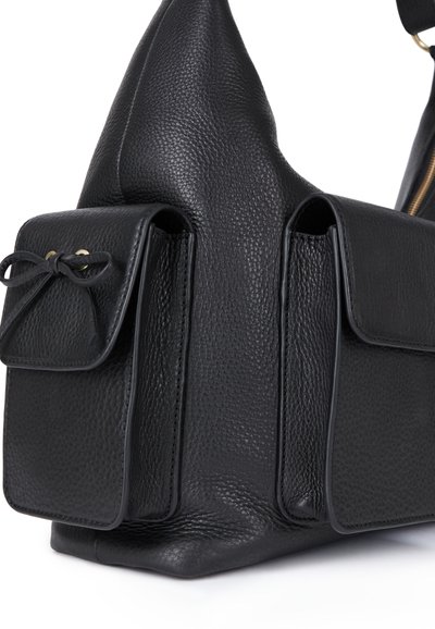 Borsa a mano nera in pelle con finitura texturizzata, caratterizzata da due tasche frontali con dettagli a fiocco e una forma triangolare distintiva.