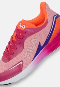 Scarpa da ginnastica rosa con tomaia in rete, dettagli arancioni e rifiniture viola. Presenta una suola testurizzata e una striscia bianca a contrasto sul lato.
