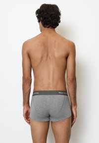 Boxer in cotone grigio con cintura elastica con logo "Marc O’Polo". Il tessuto ha una texture liscia e una forma aderente.