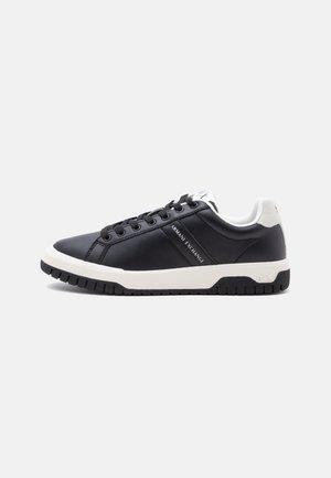 Μαύρο χαμηλό sneaker με λευκή σόλα και φτέρνα, μαύρα κορδόνια και λογότυπο Armani Exchange στο πλάι και στη γλώσσα.