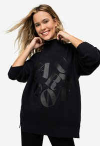 Navy oversized Pullover aus strukturiertem Strickgewebe, mit hohem Kragen und auffälligem schwarzen Grafikdruck auf der Vorderseite. Seitenschlitze für zusätzlichen Komfort.