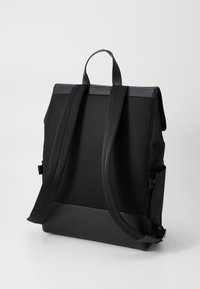 Sac à dos noir avec un dos en mesh texturé, un panneau supérieur épuré, des bretelles solides et des poches latérales. Fabriqué en matériaux durables avec un design moderne.