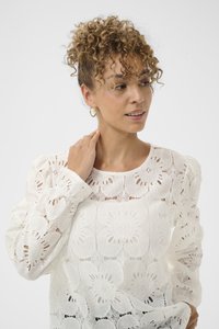 Witte kanten blouse met bloemige patronen, ronde halslijn, puffed mouwen en een gestructureerde afwerking. Het model raakt lichtjes haar hals aan.