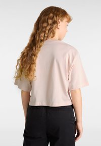 Ljusrosa kortärmad t-shirt i cropped-modell, gjord av mjuk bomull, med en enkel design och rundad halsringning.