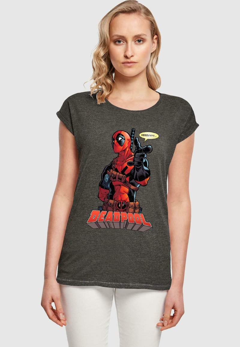 Tamsiai pilka marškinėliai su trumpomis rankovėmis, kuriuose yra didelis Deadpool grafika raudona ir juoda spalvomis, su detaliais akcentais ir drąsiu tekstu apačioje.