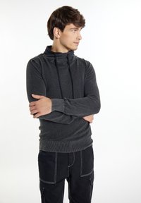 Dunkelgrauer Kapuzenpullover mit strukturiertem Muster, verstellbarem Kordelzug und gerippten Bündchen, kombiniert mit schwarzen Hosen mit kontrastierenden Nähten.