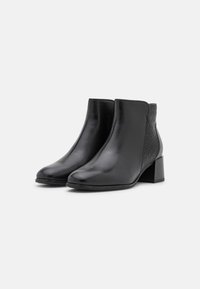 Botas negras hasta el tobillo con un frente de cuero liso y paneles laterales texturizados con patrón. Diseño de tacón cuadrado para mayor estabilidad.