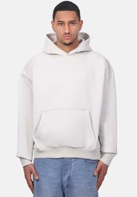 Kapuzensweatshirt in hellbeige, aus weichem Stoff; mit einer Fronttasche und gesticktem Logo. Lockere Passform mit gerippten Bündchen.