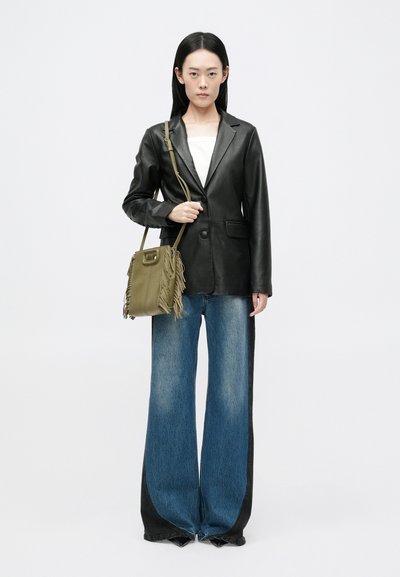 Musta nahkatakki, valkoinen toppi, leveälahkeiset siniset farkut mustilla sivupaneeleilla ja oliivinvihreä fringekäsiolkalaukku.