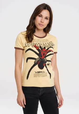 Gelbes T-Shirt mit braunem Ringerkragen, das ein Spider-Man-Logo und Text zeigt. Weiches Baumwollmaterial mit einem enganliegenden Design.