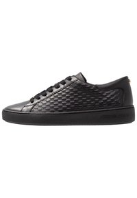 Sneaker in pelle nera con pannello laterale testurizzato, lacci piatti e punta rotonda. Caratterizzati da una suola resistente e un marchio in rilievo sul tallone.