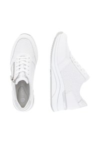 Chaussures de sport blanches avec un design perforé, dotées de lacets et d'une fermeture éclair sur le côté, semelle en caoutchouc légèrement surélevée et intérieur rembourré.