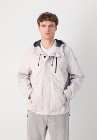 Light grey waterproof jacket with a drawstring hood, elastic cuffs, two front pockets, and black detailing on the interior.