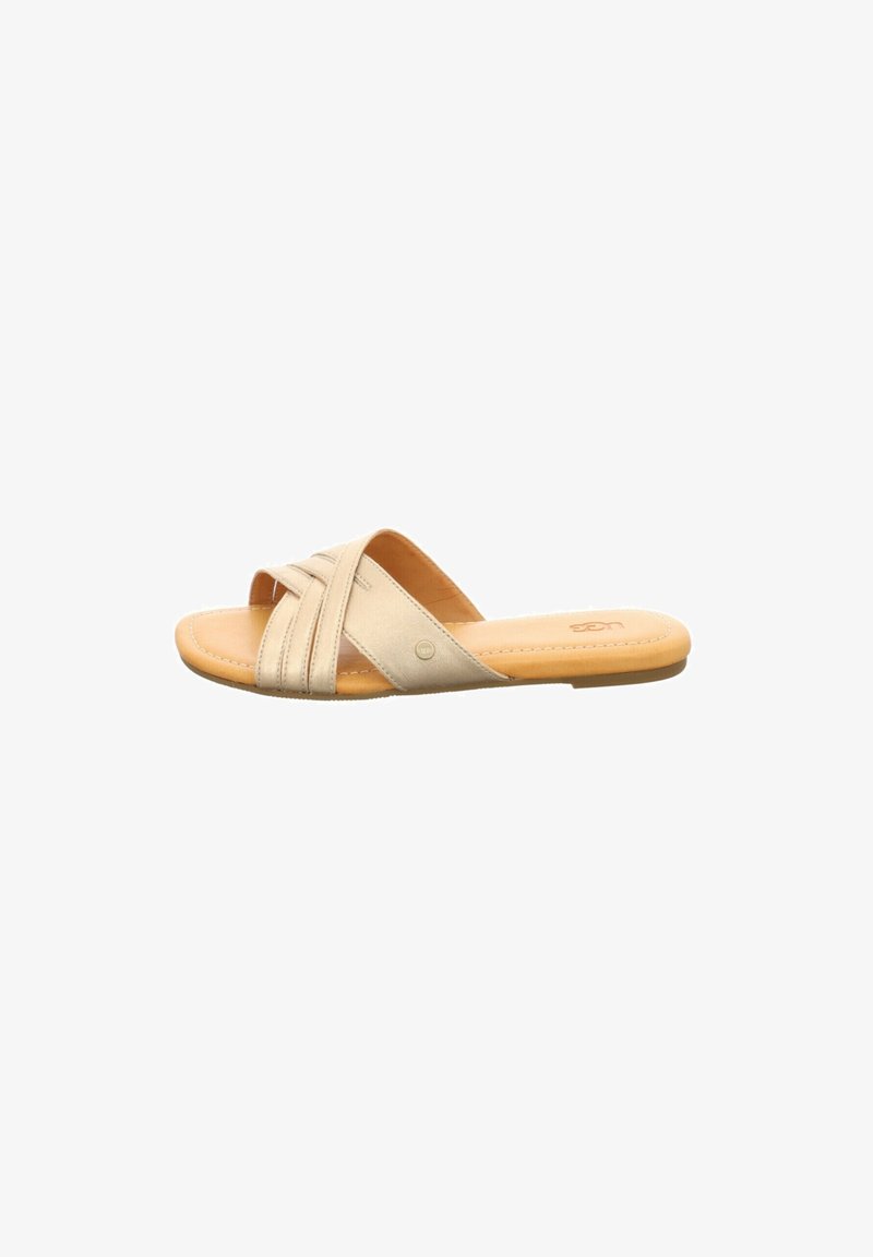 Beige slip-on sandal with crisscross straps and cushioned tan insole, flat sole, minimalist design for casual wear.