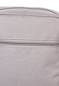 Hellgraue Stofftasche mit strukturiertem Oberflächen und einem horizontalen Reißverschluss an der Oberseite. Klassische rechteckige Form für funktionale Nutzung.