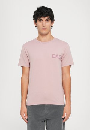 Kortærmet lyserød t-shirt lavet af blødt stof, med en diskret "DAD" grafik på venstre brystområde. Casual pasform, rund halsudskæring.