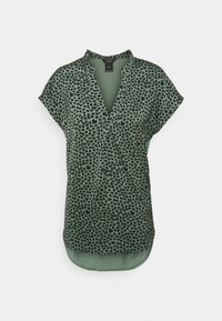 Top a maniche corte verde con motivo floreale nero, caratterizzato da un design a scollo a V e un orlo posteriore leggermente più lungo. Realizzato in tessuto leggero.