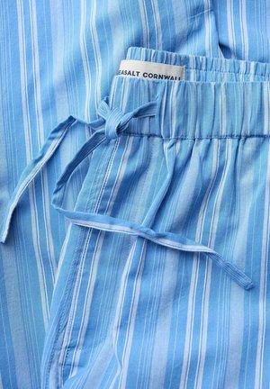 Blue and white vertical striped fabric with elastic waistband and tied drawstring, showing a tag labeled "Seasalt Cornwall."