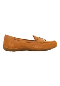 Mocasín de ante beige con detalles de costura y un lazo decorativo. Suela de goma plana con un discreto patrón de agarre y cortes laterales para ventilación.