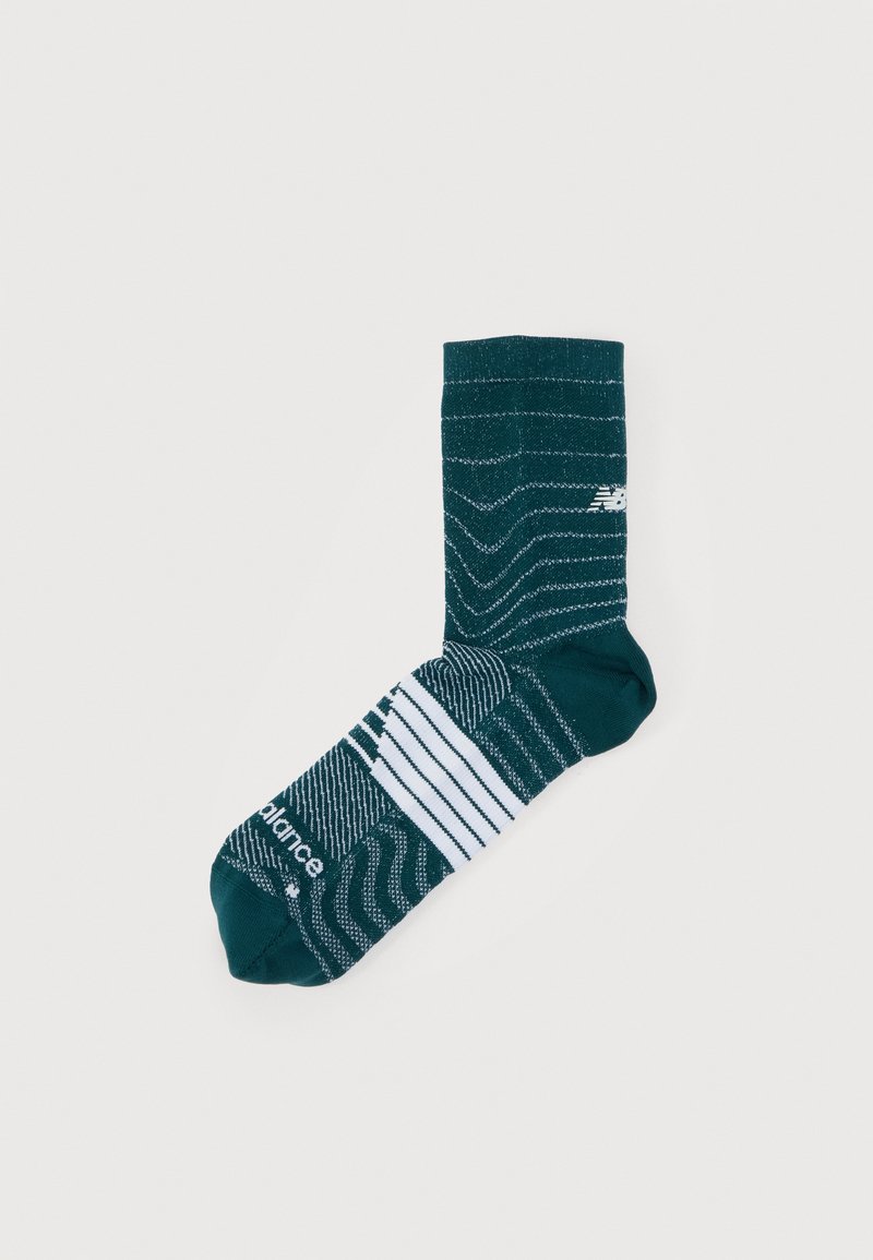 Κάλτσες σε τυρκουάζ χρώμα με υφή κυματιστού μοτίβου, λευκές ριγέ λεπτομέρειες και μικρό λογότυπο. Το υλικό φαίνεται λείο με μήκος μέχρι το μέσο της γάμπας.