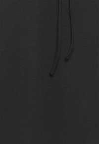 Tela de algodón negra con una textura suave, que presenta un detalle de cordón. La apariencia general es sencilla y sin adornos.