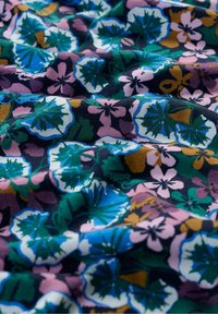 Floral fabric with a navy background, featuring pink, purple, and green flowers. Texture appears soft with a slightly crinkled look.