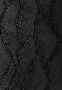 Tissu noir avec un motif en zigzag texturé présentant des formes losanges en relief aux bords rugueux et des sections lisses en rangs alternés.