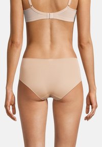 Beige nahtlose Unterwäsche mit hoher Taille und glatter Textur, die für Komfort entworfen wurde. Der weiche Stoff und die subtilen Nähdetails sind sichtbar.