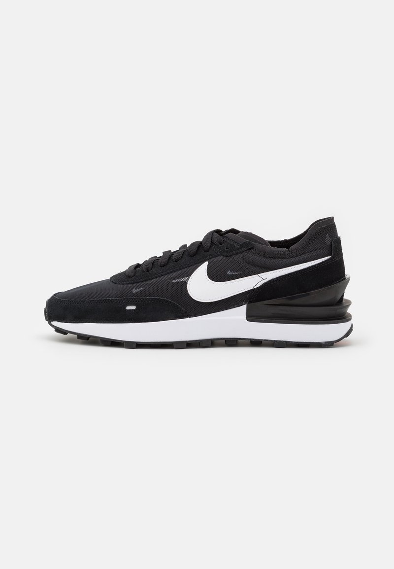 Scarpe sportive nere con una tomaia in suede e mesh, logo Nike bianco, suola in gomma nera e intersuola bianca a contrasto. Design con lacci.