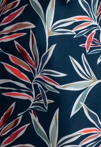 Marine stof met een botanisch bladerenpatroon; bladeren in rood, groen en beige met witte omtrekken. Glad textuur, levendige kleuren en gedetailleerd ontwerp.