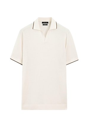 Polo in colore crema con scollo a V e bordo scuro a contrasto su colletto e maniche. Tessuto morbido, maniche corte.