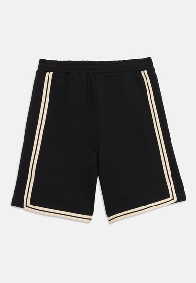 Μαύρο αθλητικό σορτς με ελαστική μέση και κρεμ διπλές ρίγες κατά μήκος των πλευρών και γύρω από τα ανοίγματα στα πόδια.