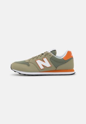 Baskets New Balance vert olive et orange avec logo blanc, semelle intermédiaire blanche, semelle extérieure noire et fermeture à lacets, vues de profil.